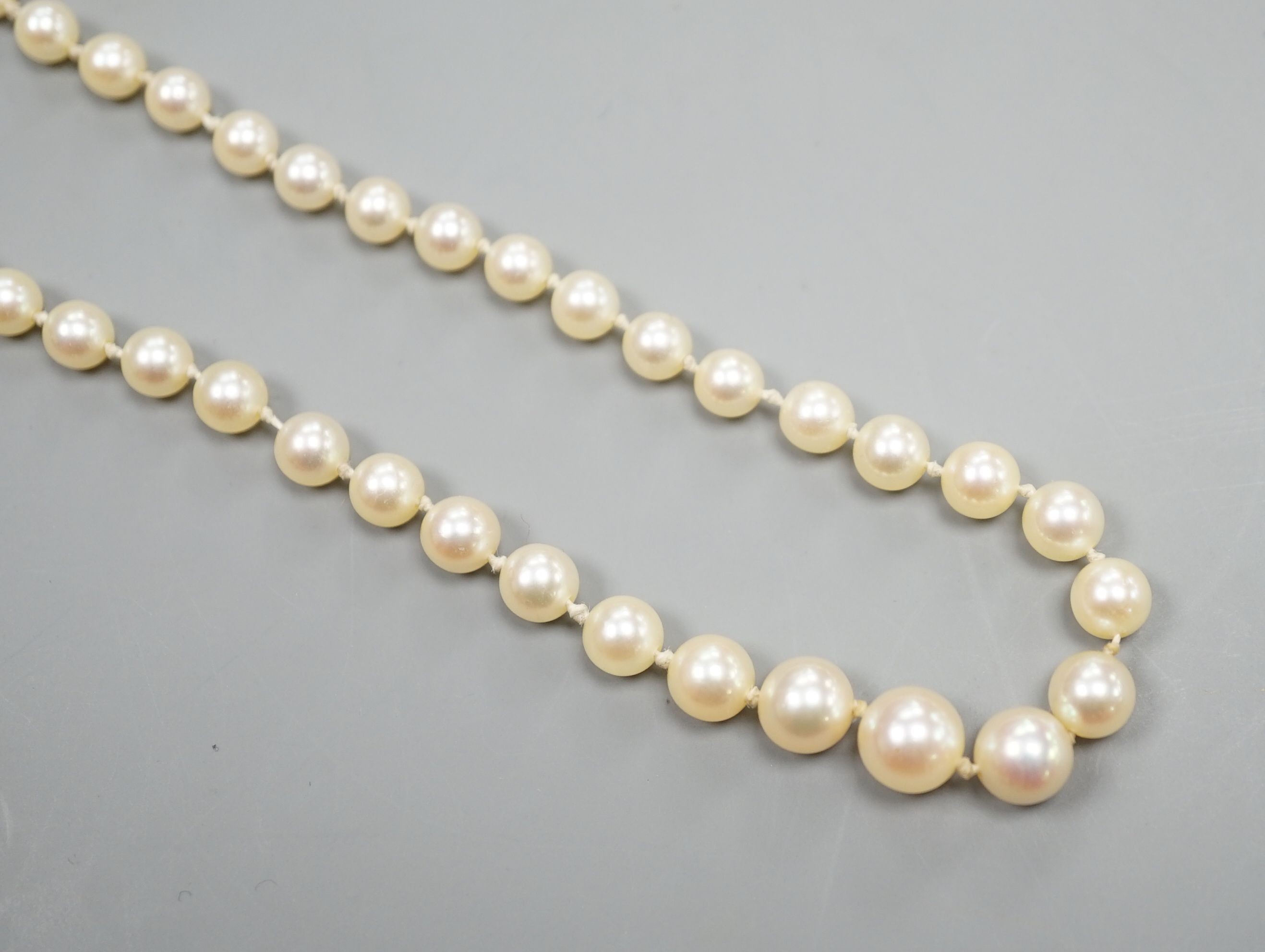 A single strand graduated cultured pearl necklace, with four stone diamond set white metal clasp, 50cm, gross weight 14.4 grams (pearls have not been tested).